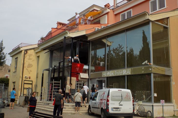 I dok klijenti banke čekaju ispred ulaza, radnici im rade iznad glava, a iskre frcaju po njima (N. ORLOVIĆ RADIĆ)