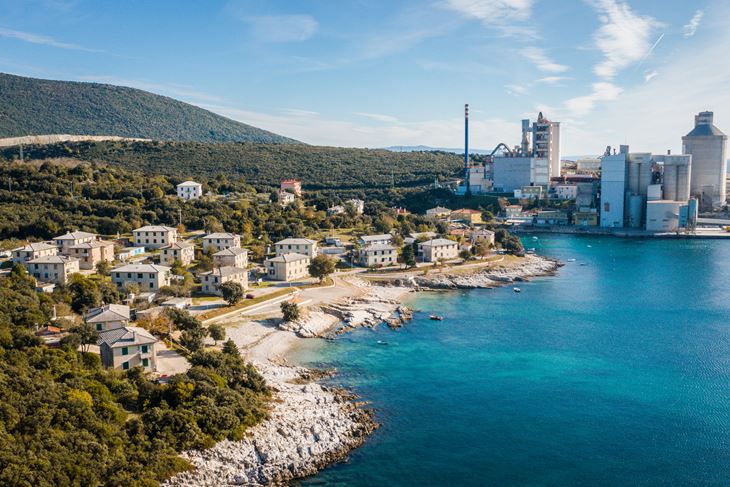 Holcim je u tvornici u Koromačnu emisije CO2 po toni cementa u odnosu na 1990. godinu do sad smanjio za 30%. Sve su emisije iz dimnjaka uvijek značajno ispod graničnih vrijednosti, a prema mjerenjima kvaliteta i zraka i mora je prve kategorije (Fotografija: TZ Općina Raša, fotograf Mateo Gobo)